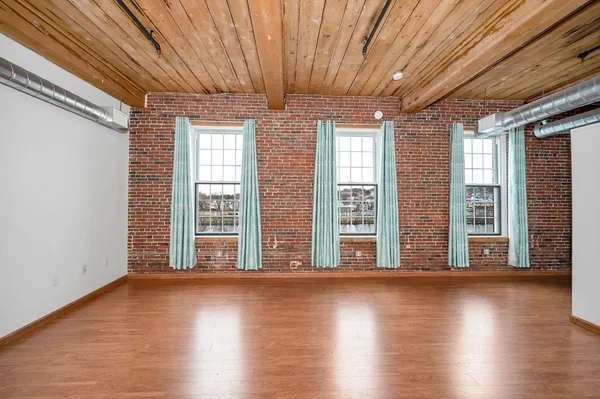 a view of room with wooden floor and large window