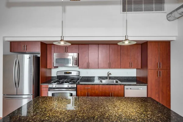 a kitchen with granite countertop stainless steel appliances and wooden cabinets