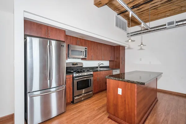 a kitchen with stainless steel appliances granite countertop a refrigerator sink and stove