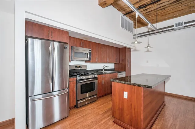 a kitchen with stainless steel appliances granite countertop a refrigerator sink and stove