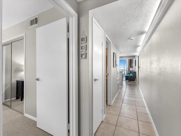 a hallway view with three rooms