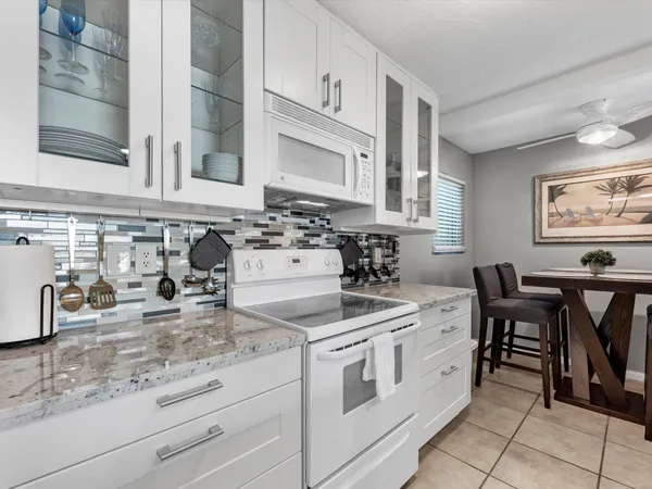 a kitchen with appliances a cabinets and chairs