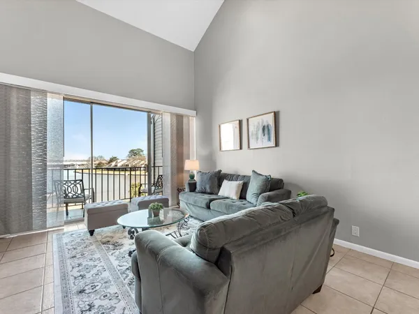 a living room with furniture and a floor to ceiling window