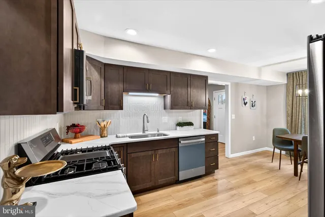 a room with a chair and white cabinets