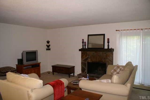 5454 Pine Top Circle Raleigh, NC 27612 - Photo 3 of 10 a living room with furniture a fireplace and a flat screen tv