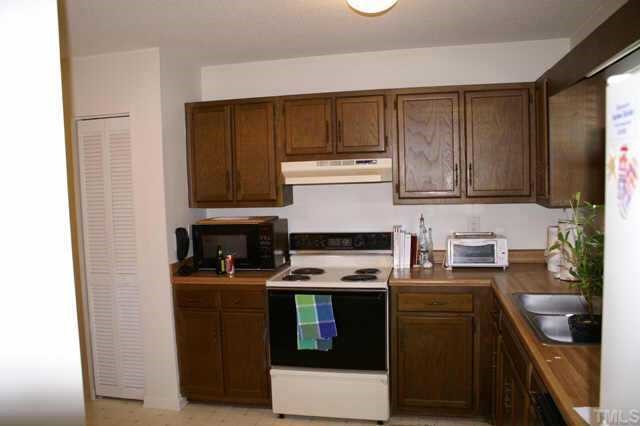 5454 Pine Top Circle Raleigh, NC 27612 - Photo 7 of 10 a kitchen with stainless steel appliances a stove a sink a refrigerator and cabinets
