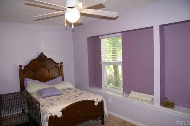 5454 Pine Top Circle Raleigh, NC 27612 - Photo 9 of 10 a bedroom with a bed and a chandelier