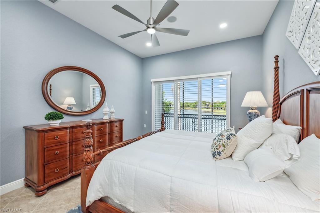 9259 Museo Circle, Unit 201 Naples, FL 34114 - Photo 14 of 50 a bedroom with a bed a mirror and a large window