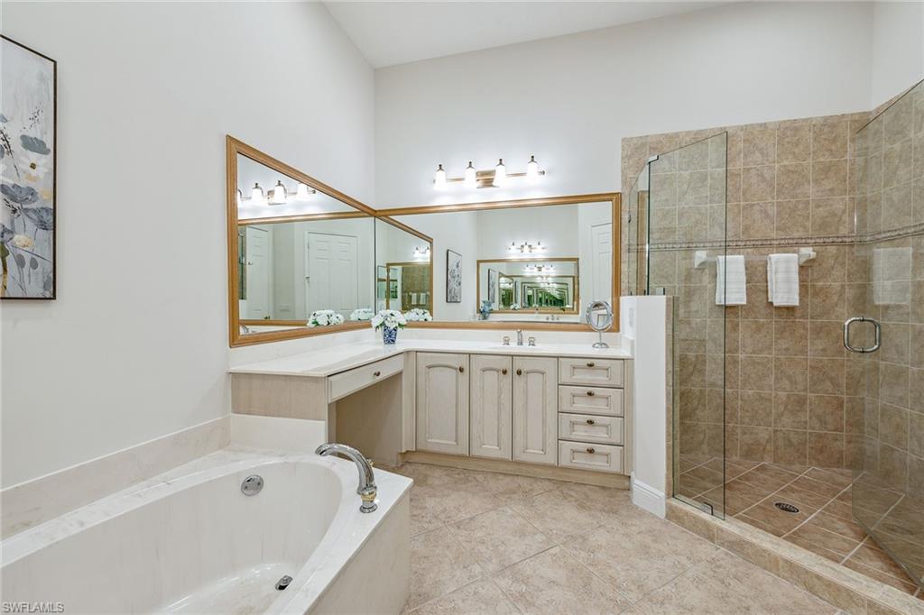 9259 Museo Circle, Unit 201 Naples, FL 34114 - Photo 16 of 50 a bathroom with a tub sink and mirror