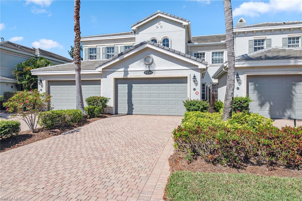9259 Museo Circle, Unit 201 Naples, FL 34114 - Photo 33 of 50 a front view of a house with a yard and garage