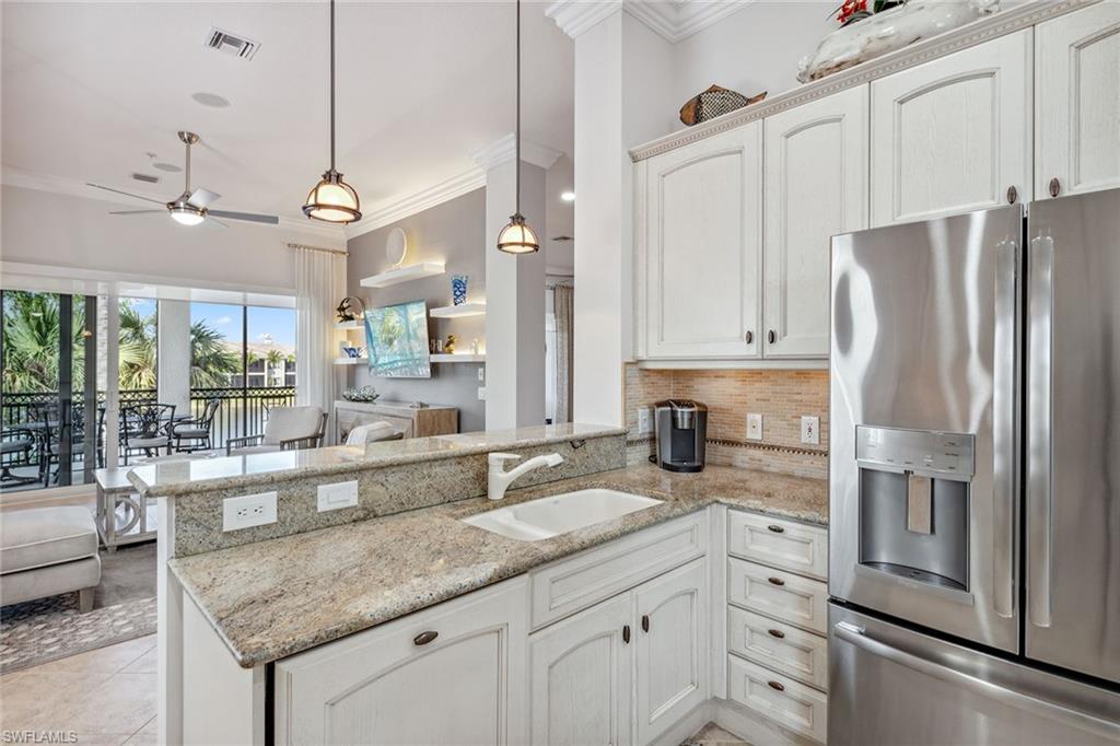 9259 Museo Circle, Unit 201 Naples, FL 34114 - Photo 4 of 50 a kitchen with granite countertop a sink appliances and cabinets