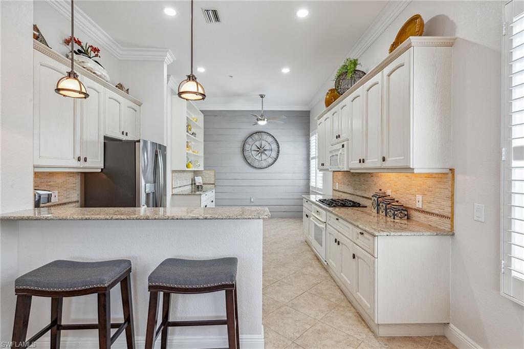 9259 Museo Circle, Unit 201 Naples, FL 34114 - Photo 6 of 50 a kitchen with stainless steel appliances granite countertop counter space a sink and cabinets