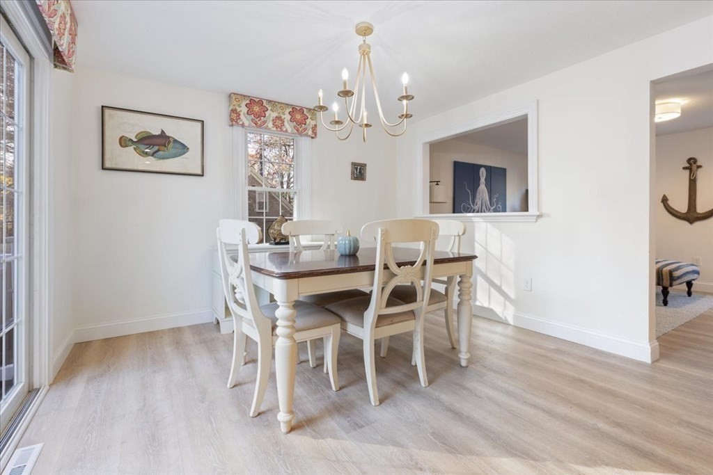 294 County Road Hanson, MA 02341 - Photo 12 of 38 a dining room with wooden floor a chandelier a wooden table and chairs