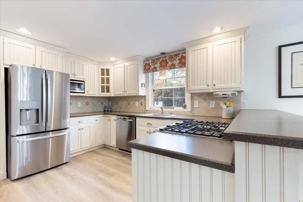 294 County Road Hanson, MA 02341 - Photo 7 of 38 a kitchen with stainless steel appliances granite countertop a stove a sink dishwasher a refrigerator and cabinets with wooden floor