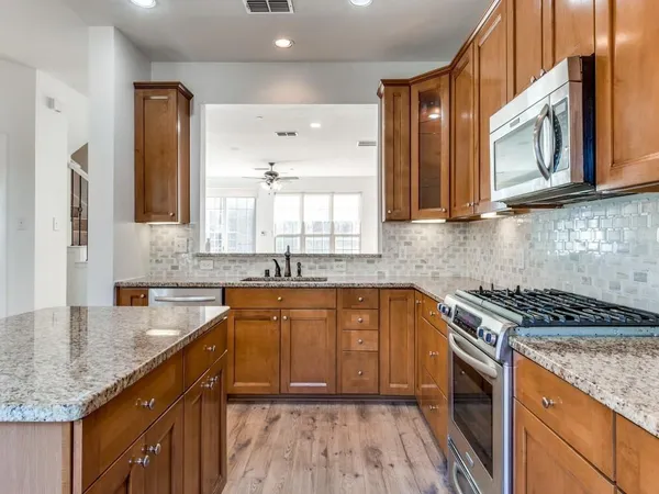 a kitchen with stainless steel appliances granite countertop a sink stove and cabinets