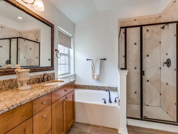 a bathroom with a granite countertop tub sink and mirror