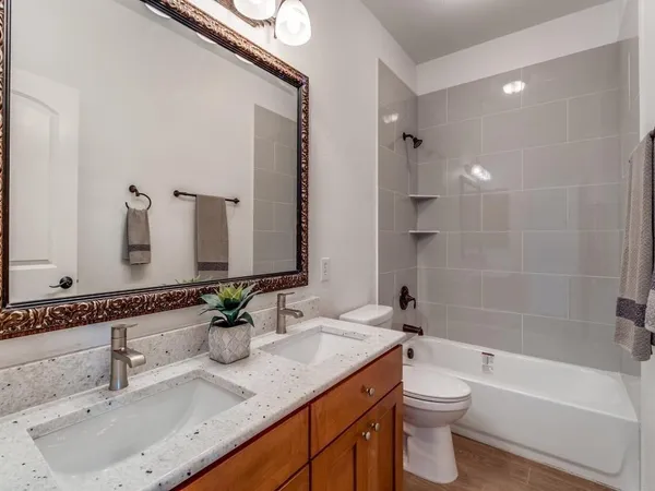 a bathroom with a granite countertop sink a toilet and bathtub