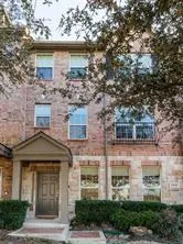 front view of a brick house with a small yard