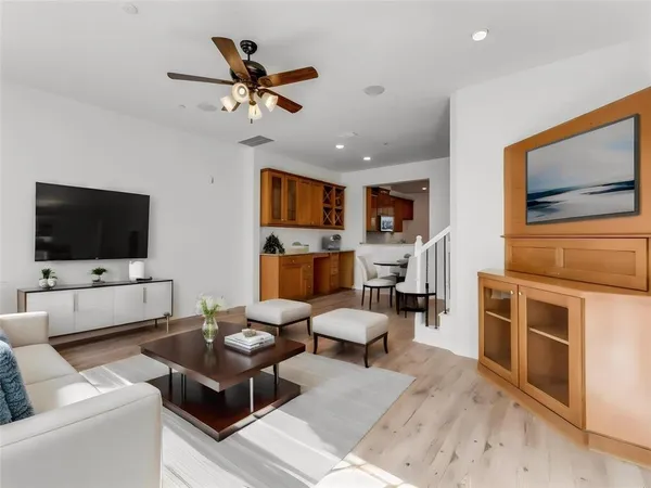 a living room with furniture kitchen view and a flat screen tv