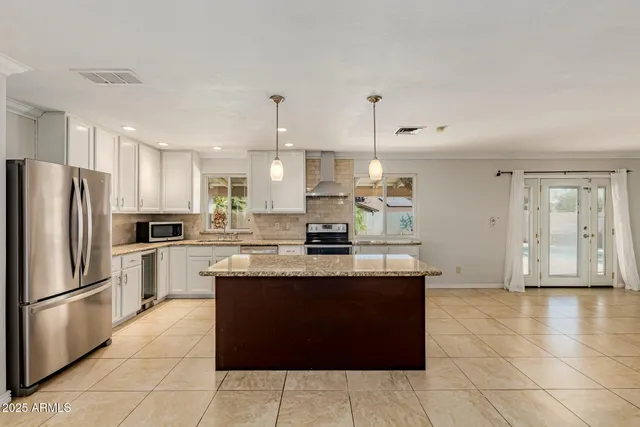 a kitchen with stainless steel appliances granite countertop a refrigerator and a stove