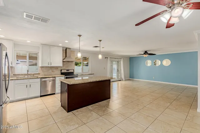 a large kitchen with granite countertop a stove top oven a sink a counter space and cabinets