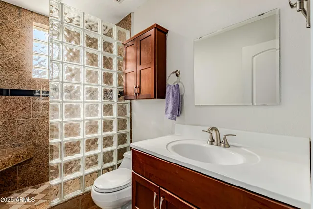 a bathroom with a sink toilet a mirror and shower