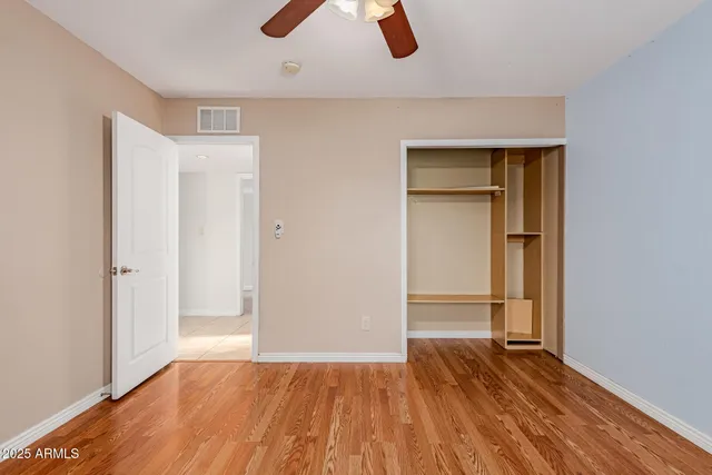 an empty room with closet and windows