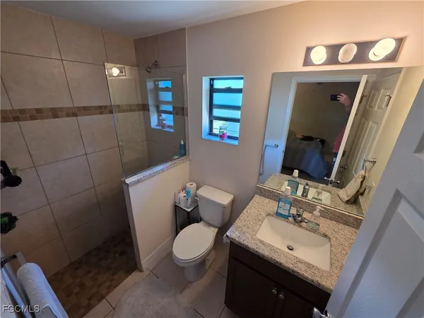 a bathroom with a sink mirror vanity and toilet