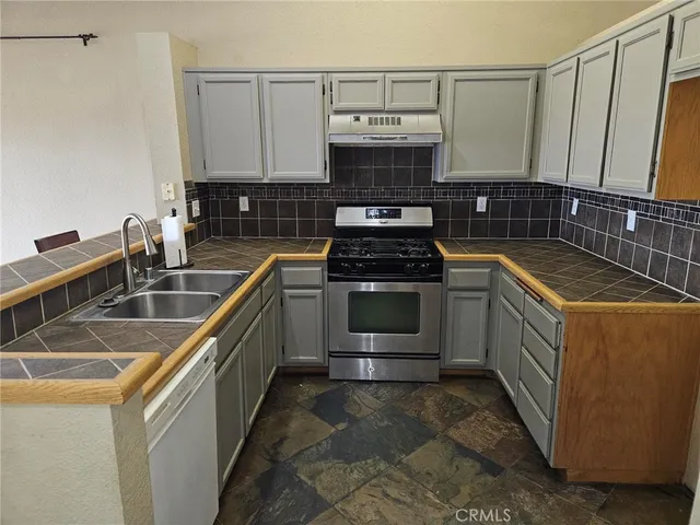 a kitchen with a sink stove and cabinets