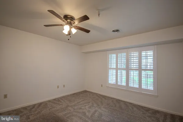a view of a room with a ceiling fan and a window