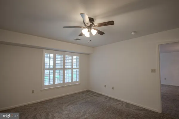 a view of a room with a ceiling fan and a fan