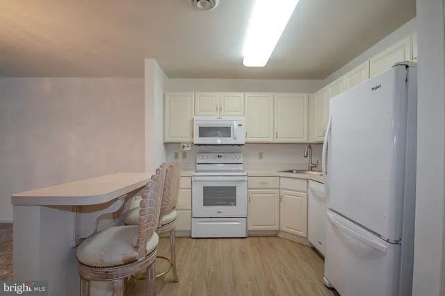 a room with kitchen island a sink cabinets and wooden floor