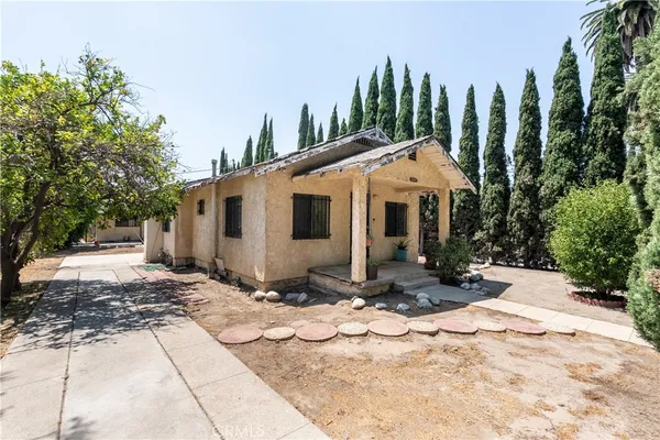 a front view of a house with a yard and trees