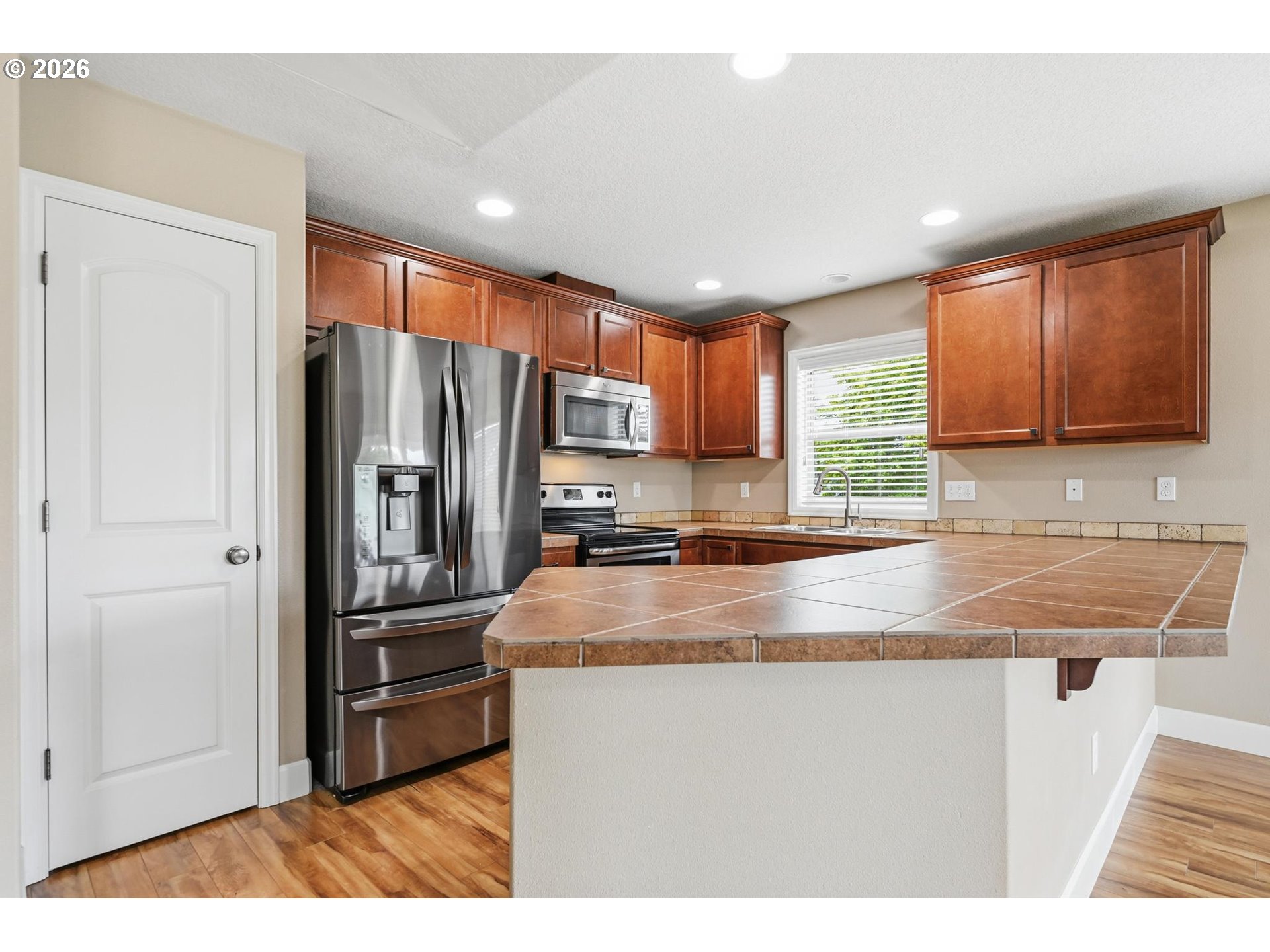1075 Sage Street Silverton, OR 97381 - Photo 29 of 46 a kitchen with stainless steel appliances granite countertop a refrigerator a sink a stove a microwave and island