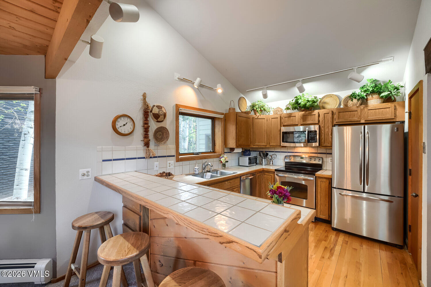 128 Beaver Road, Unit EAST Eagle-Vail, CO 81620 - Photo 5 of 21 a kitchen that has a kitchen island wooden cabinets and stainless steel appliances