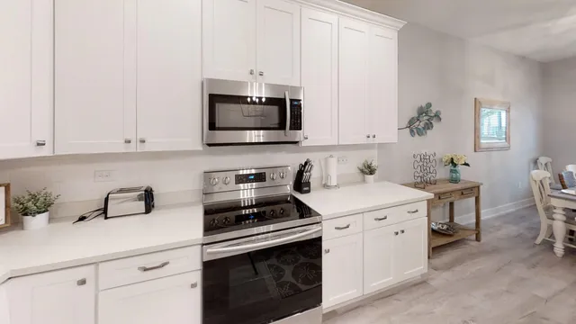 a kitchen with cabinets stainless steel appliances and wooden floor