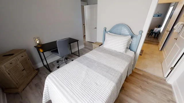 a bedroom with a bed and hardwood floor