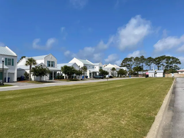a front view of a house with a garden and trees