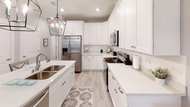 a kitchen with white cabinets sink and stainless steel appliances