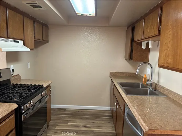 a kitchen with granite countertop a sink stove and cabinets