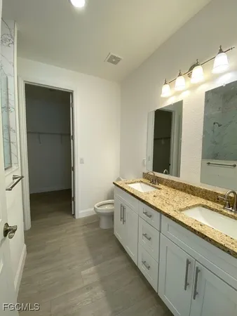 a spacious bathroom with a granite countertop sink and a mirror