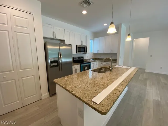 a kitchen with stainless steel appliances granite countertop a sink refrigerator and cabinets
