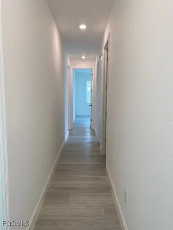 a view of a hallway with wooden floor