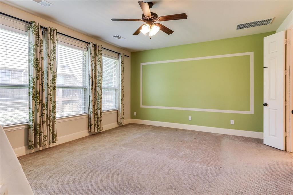 419 Rio Grande Drive Irving, TX 75039 - Photo 16 of 29 Spacious room featuring multiple windows with blinds and decorative curtains, a ceiling fan with integrated lighting, wall trim detailing, and carpeted flooring