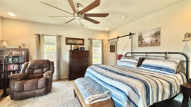 a bedroom with a balcony a bed a couch and dresser