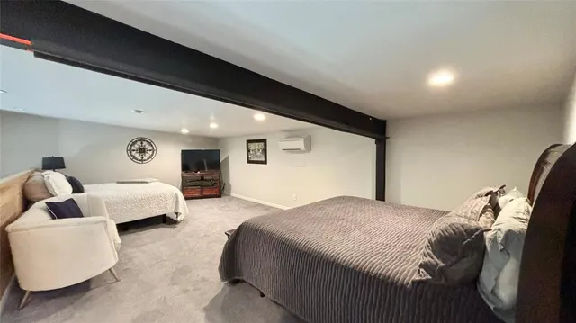 a spacious bedroom with a bed and a flat screen tv