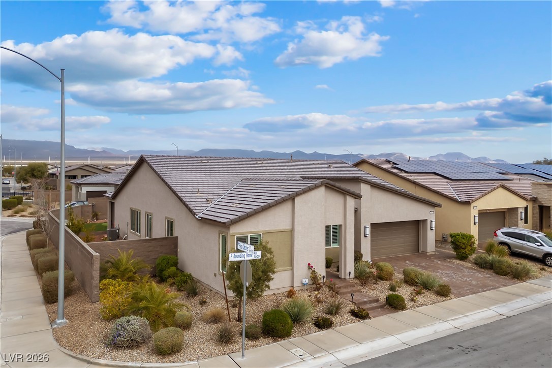 3018 Bounding Home Road North Las Vegas, NV 89086 - Photo 1 of 43 View of front of home with stucco siding, a tile roof, driveway, a mountain view, and an attached garage