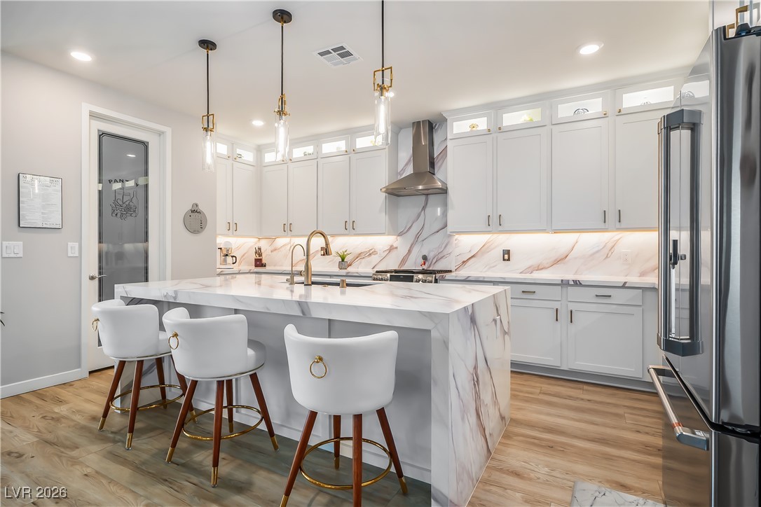 3018 Bounding Home Road North Las Vegas, NV 89086 - Photo 16 of 43 Kitchen featuring backsplash, high quality fridge, light stone countertops, white cabinetry, and recessed lighting