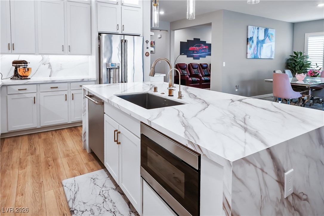 3018 Bounding Home Road North Las Vegas, NV 89086 - Photo 19 of 43 Kitchen featuring white cabinets, hanging light fixtures, light stone counters, and recessed lighting