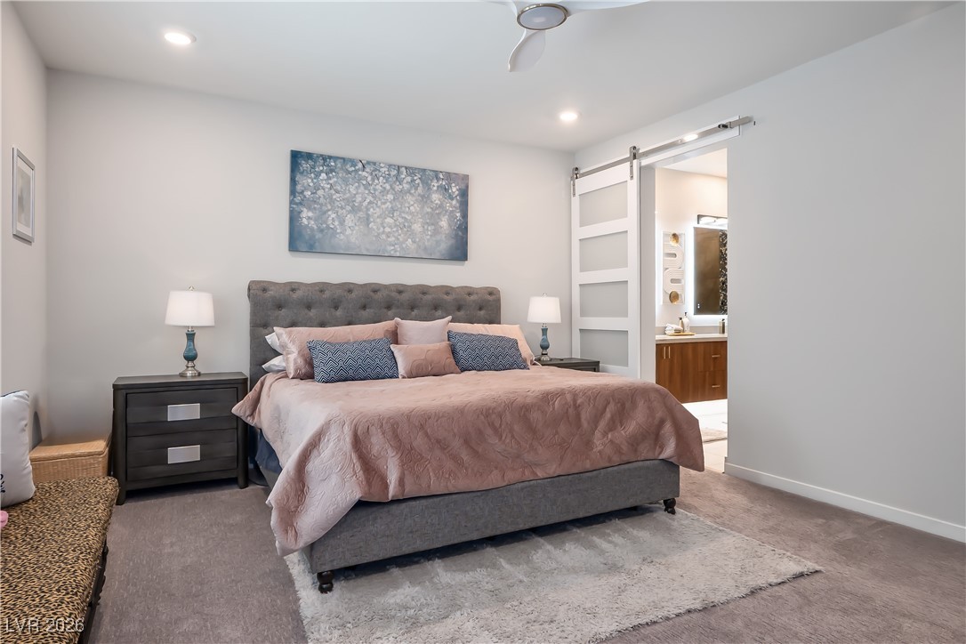 3018 Bounding Home Road North Las Vegas, NV 89086 - Photo 22 of 43 Bedroom featuring a barn door, carpet flooring, ensuite bathroom, recessed lighting, and a ceiling fan